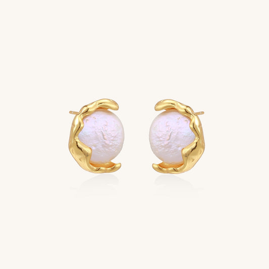 Gold-plated sterling silver stud earrings with organic claw settings cradling lustrous freshwater pearls on white background.