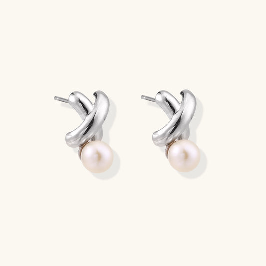 Sterling silver twisted stud earrings with round freshwater pearls on cream background, showing polished finish