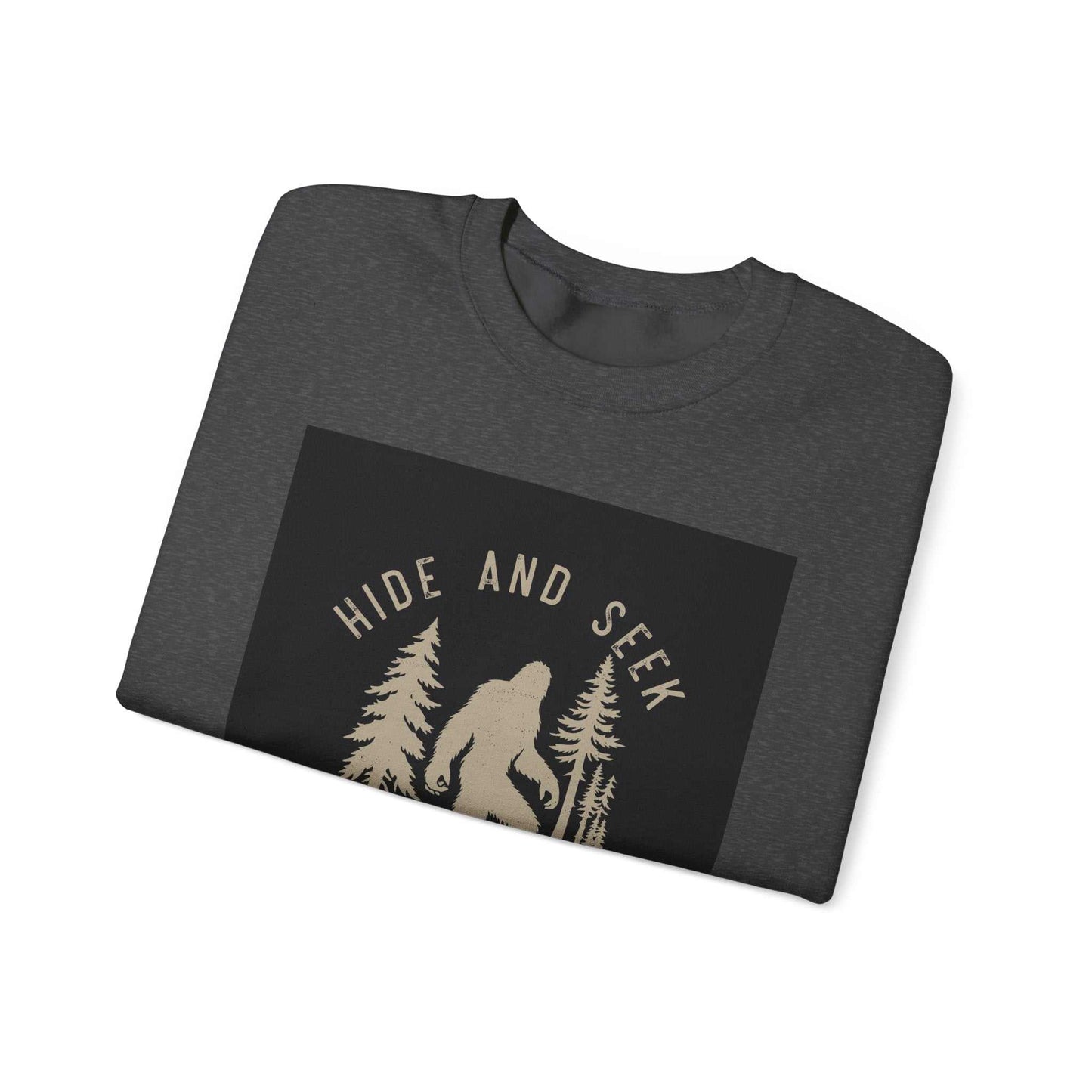 Unisex Heavy Blend™ Crewneck Sweatshirt folded, featuring "Hide and Seek" design with silhouette of Bigfoot among trees.