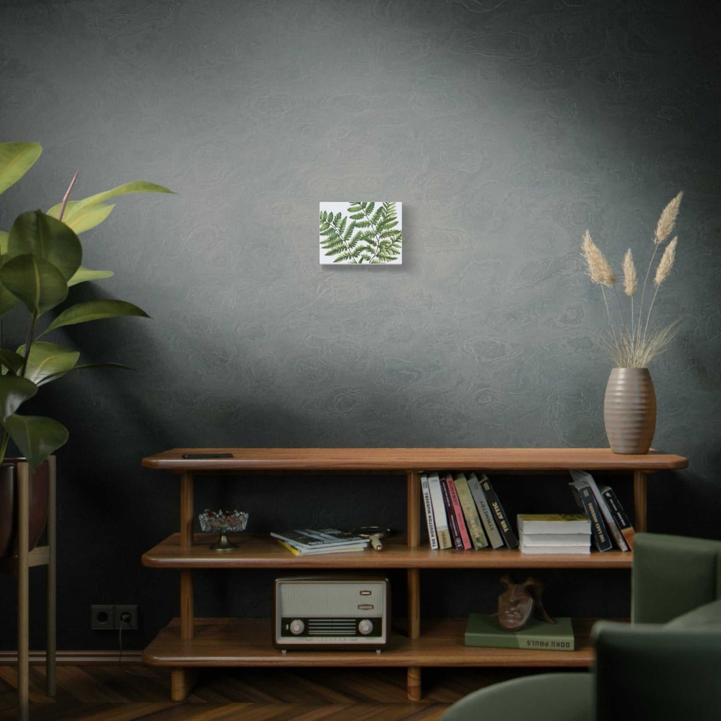 Matte canvas art displayed on a wall above a wooden shelf with books and decor.