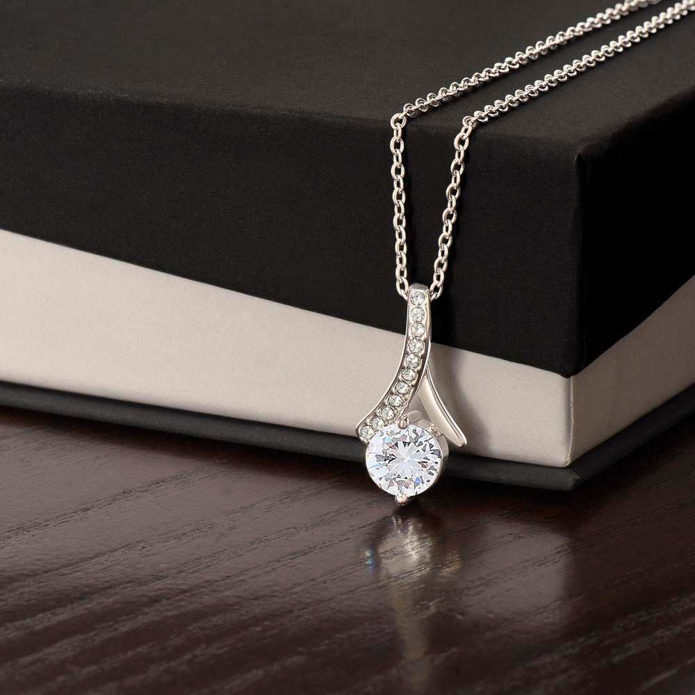 Alluring necklace with ribbon-shaped pendant, 14k white gold finish, featuring cubic zirconia on a gift box.