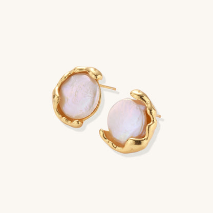 Gold-plated sterling silver stud earrings with organic claw settings cradling lustrous freshwater pearls on white background.