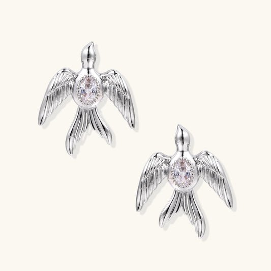 Gold-plated angel wing stud earrings with detailed feather texture and oval zirconia stones in centers