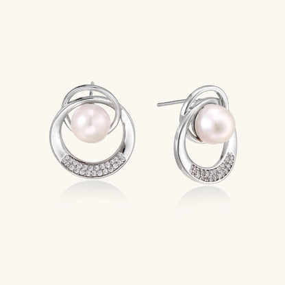 Gold-plated brass stud earrings with swirled circular design holding white freshwater pearls and small crystals