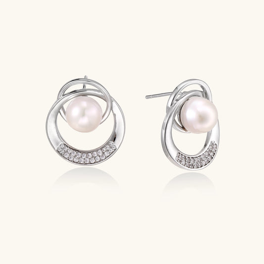 Gold-plated brass stud earrings with swirled circular design holding white freshwater pearls and small crystals