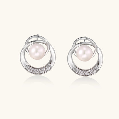 Gold-plated brass stud earrings with swirled circular design holding white freshwater pearls and small crystals