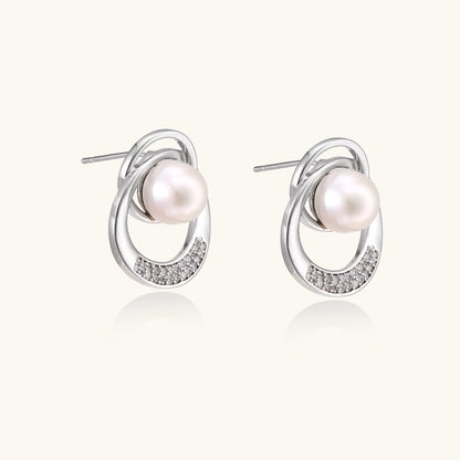 Gold-plated brass stud earrings with swirled circular design holding white freshwater pearls and small crystals