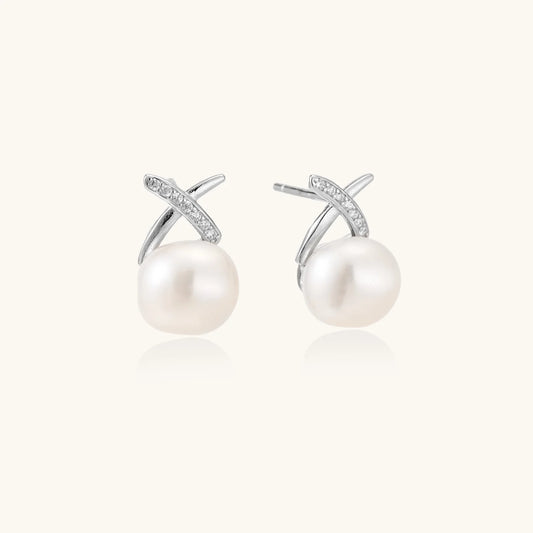 Rhodium-plated silver stud earrings with sparkling X design above lustrous round freshwater pearls on white background.
