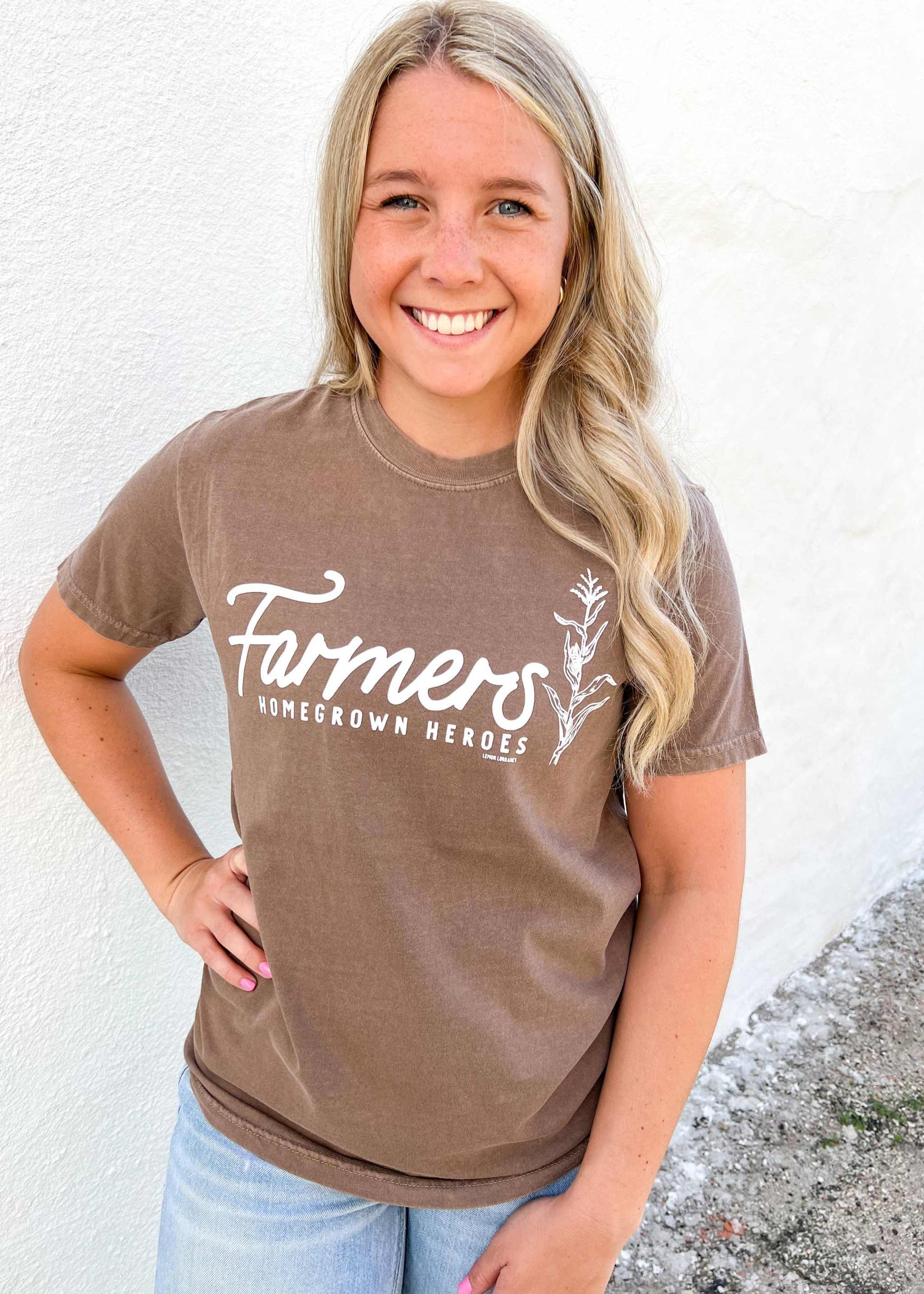 Espresso graphic tee with "Farmers: HOMEGROWN HEROES" white print, worn by a person.