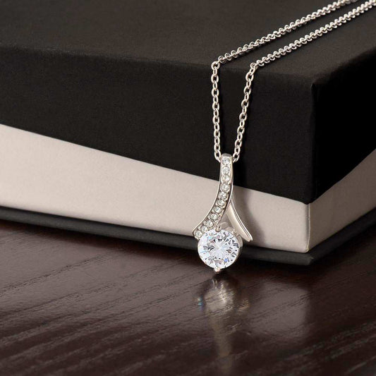 Alluring necklace with ribbon-shaped pendant, 14k white gold finish, featuring cubic zirconia on a gift box.
