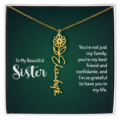Personalized sister necklace with floral design and cursive name on a green background.