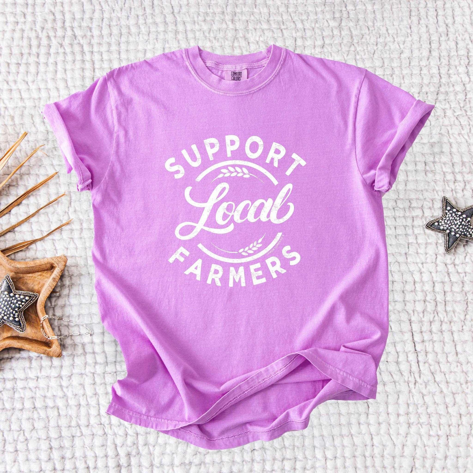Neon violet "SUPPORT LOCAL FARMERS" graphic tee with white print, unisex relaxed fit, 100% ring spun cotton.