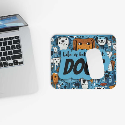 Rectangular mouse pad with dog design on a stain-resistant cloth top next to a laptop.