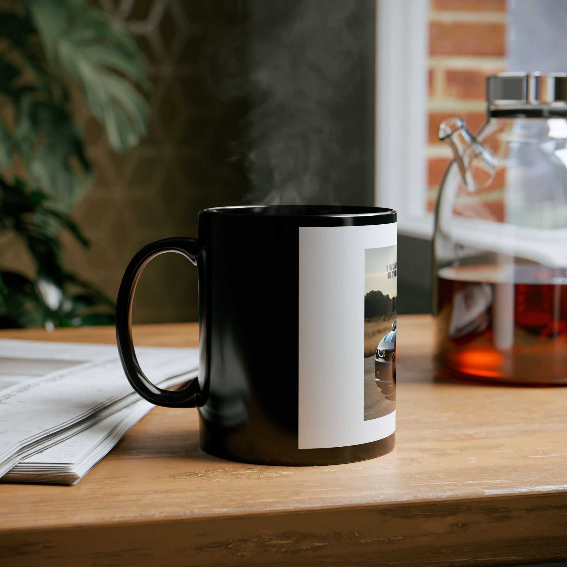Camaro Lover's Black Mug on a table beside a teapot and newspaper, showcasing sleek design and elegant style.