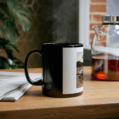 Camaro Lover's Black Mug on a table beside a teapot and newspaper, showcasing sleek design and elegant style.