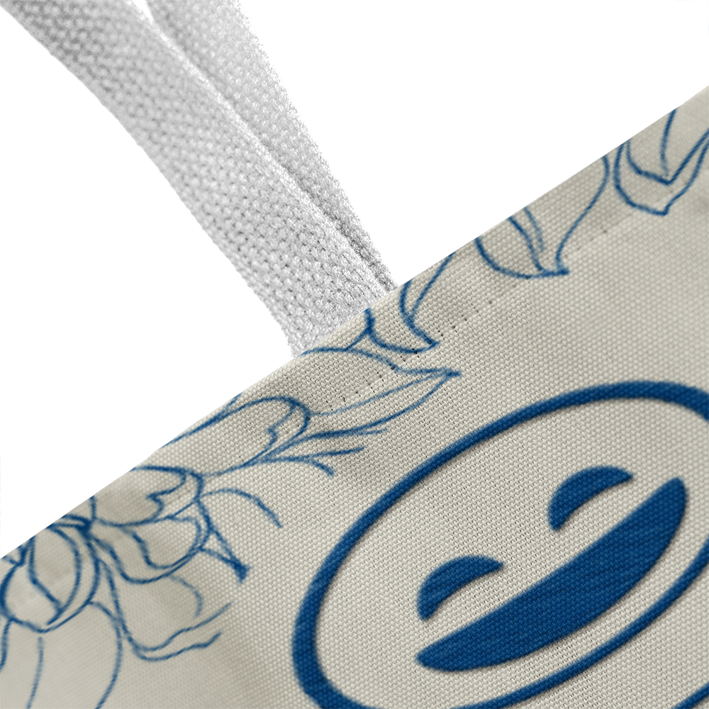 Close-up of classic tote bag with smiley design and floral pattern.