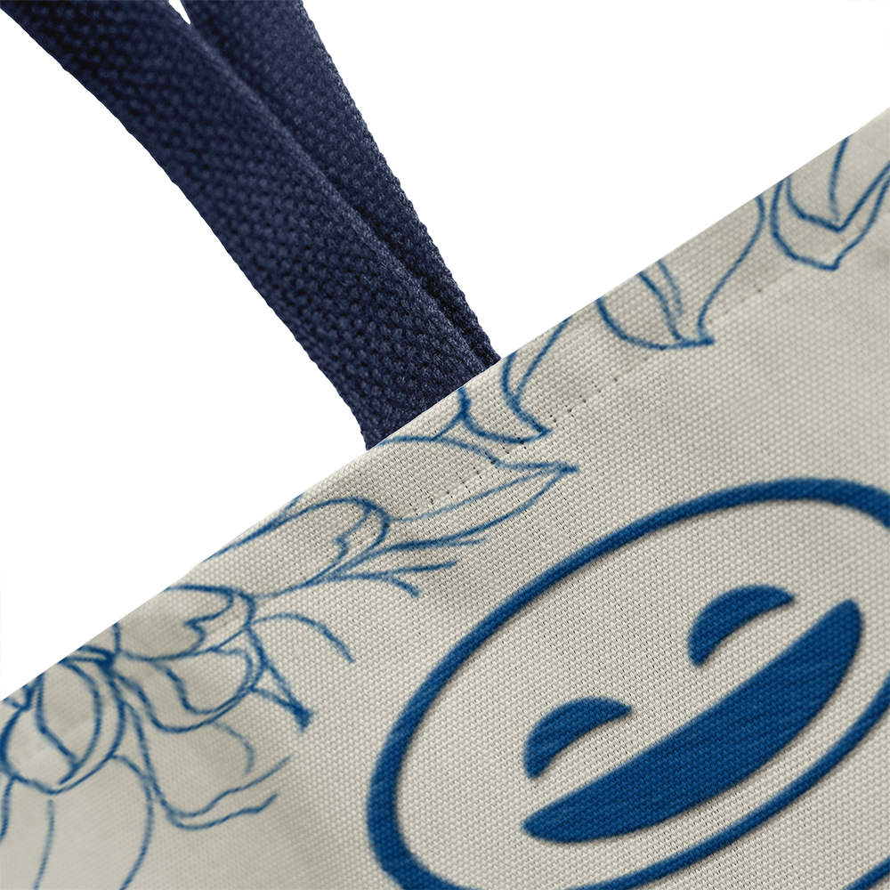 Classic tote bag with smiley face design and blue handles.